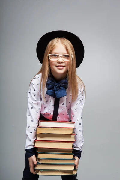 Het kind houdt een stapel boeken — Stockfoto