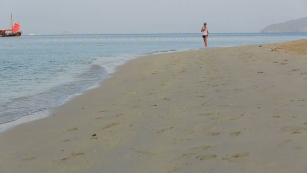Mulher correndo na praia do nascer do sol — Vídeo de Stock