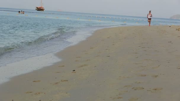 Женщина бежит на пляже Санрайз — стоковое видео