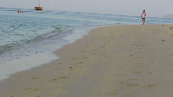 Mujer corriendo al amanecer playa — Vídeo de stock