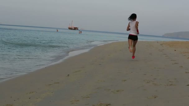 Mujer corriendo al amanecer playa — Vídeo de stock