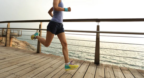 Mujer trail runner corriendo en la orilla del mar — Foto de Stock