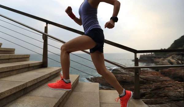 Mujer trail runner corriendo en la orilla del mar — Foto de Stock