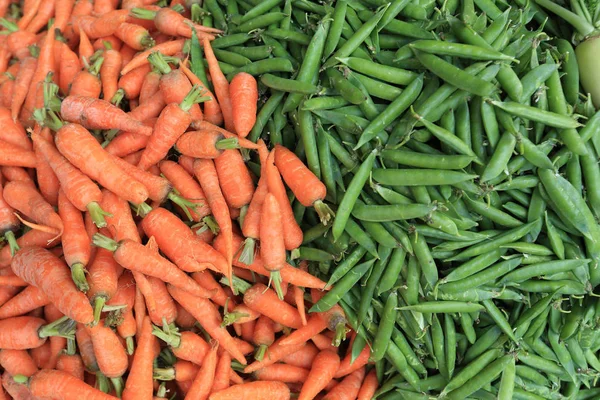 fresh carrots and green peas selling