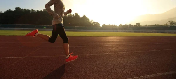 Jeune femme courant sur la piste du stade — Photo