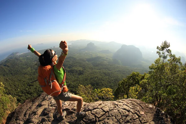 Mujer joven de pie en la cima de la montaña — Foto de Stock