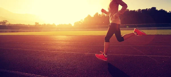 Jonge vrouw draait op stadion track — Stockfoto