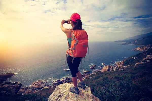 Kobiece wycieczkowicz biorąc obraz morze — Zdjęcie stockowe