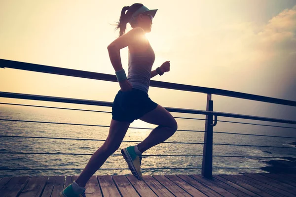 Junge Fitness-Frau läuft am Meer — Stockfoto