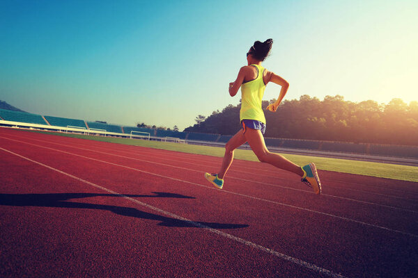 Young woman running on stadium  