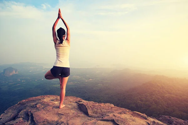 Mulher praticando ioga no pico da montanha — Fotografia de Stock