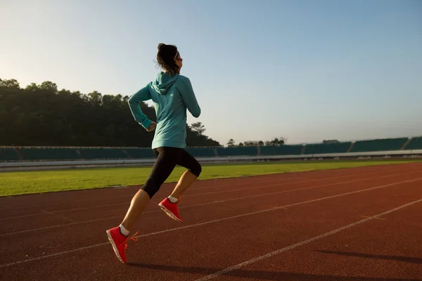 Mujer joven corriendo en el estadio — Foto de Stock