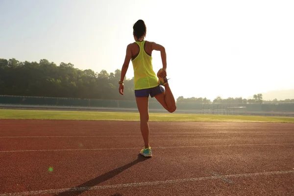 Jonge vrouw stretching benen — Stockfoto