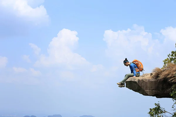 Young woman sitting on cliff — Stock Photo, Image