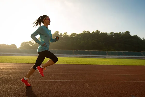 Young woman running on stadium — Stock Photo, Image