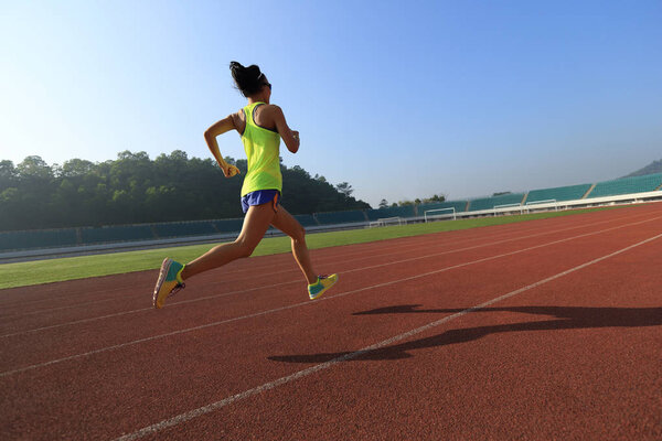 Young woman running on stadium  