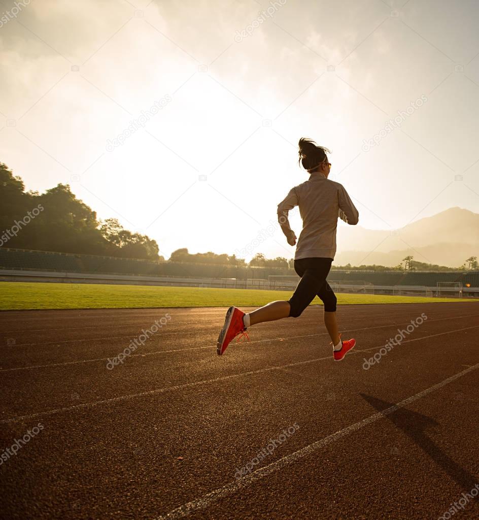 Young woman running on stadium  