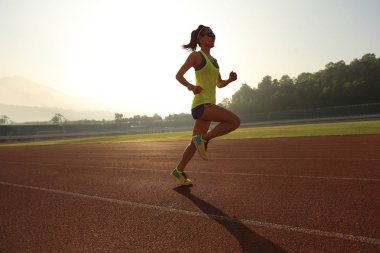 Stadyum üzerinde çalışan genç kadın  