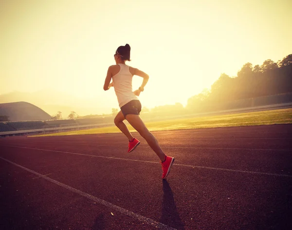 Young woman running on stadium — Stock Photo, Image