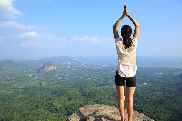 Mujer practicando yoga en el pico de la montaña — Foto de Stock