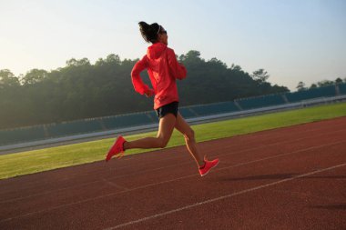Stadyum üzerinde çalışan genç kadın  