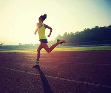 Stadyum üzerinde çalışan genç kadın  