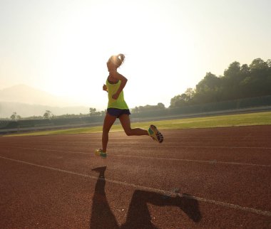 Stadyum üzerinde çalışan genç kadın  