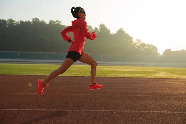 Mujer joven corriendo en el estadio — Foto de Stock