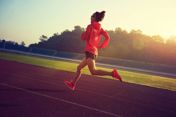 Young woman running on stadium  