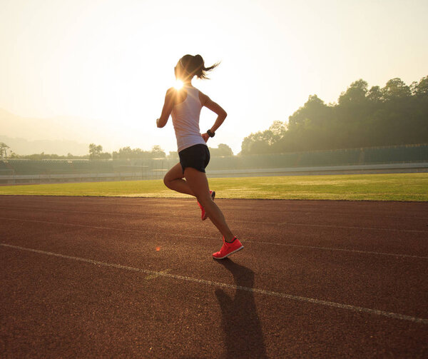 Young woman running on stadium  