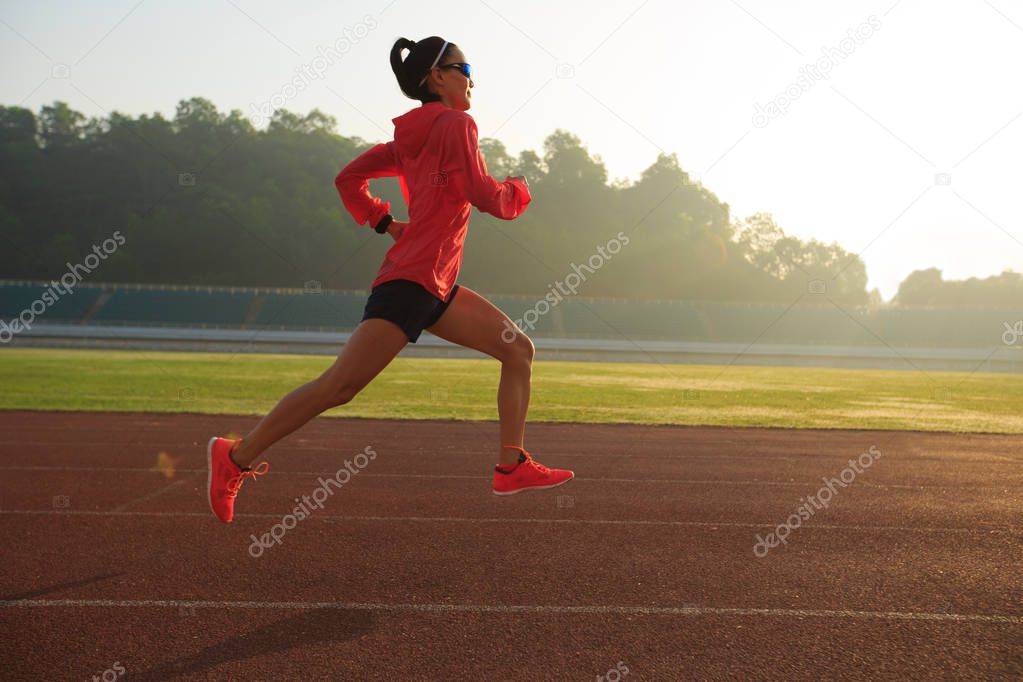 Young woman running on stadium  