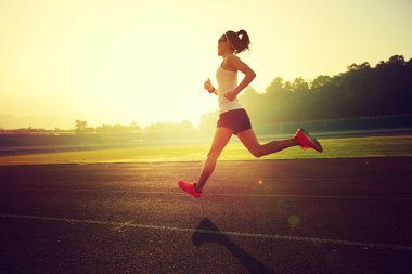 Stadyum üzerinde çalışan genç kadın  