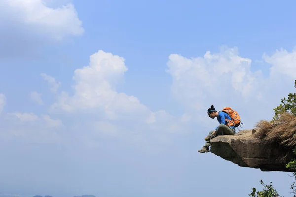 Jonge vrouw zittend op de klif — Stockfoto