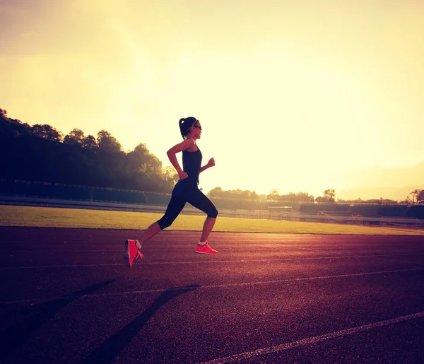 Mujer joven corriendo en el estadio — Foto de Stock