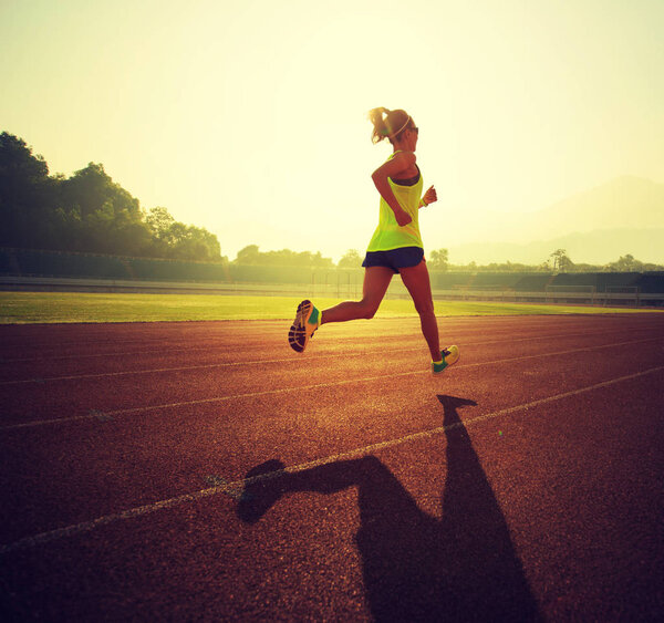 Young woman running on stadium  