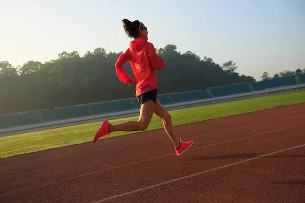 Mujer joven corriendo en el estadio — Foto de Stock