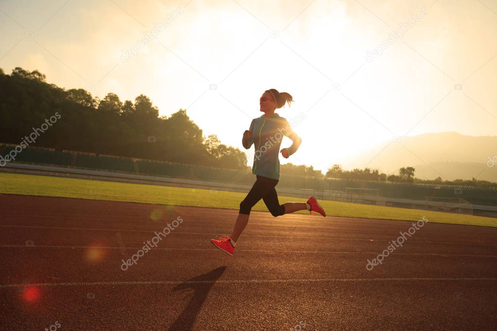 Young woman running on stadium  