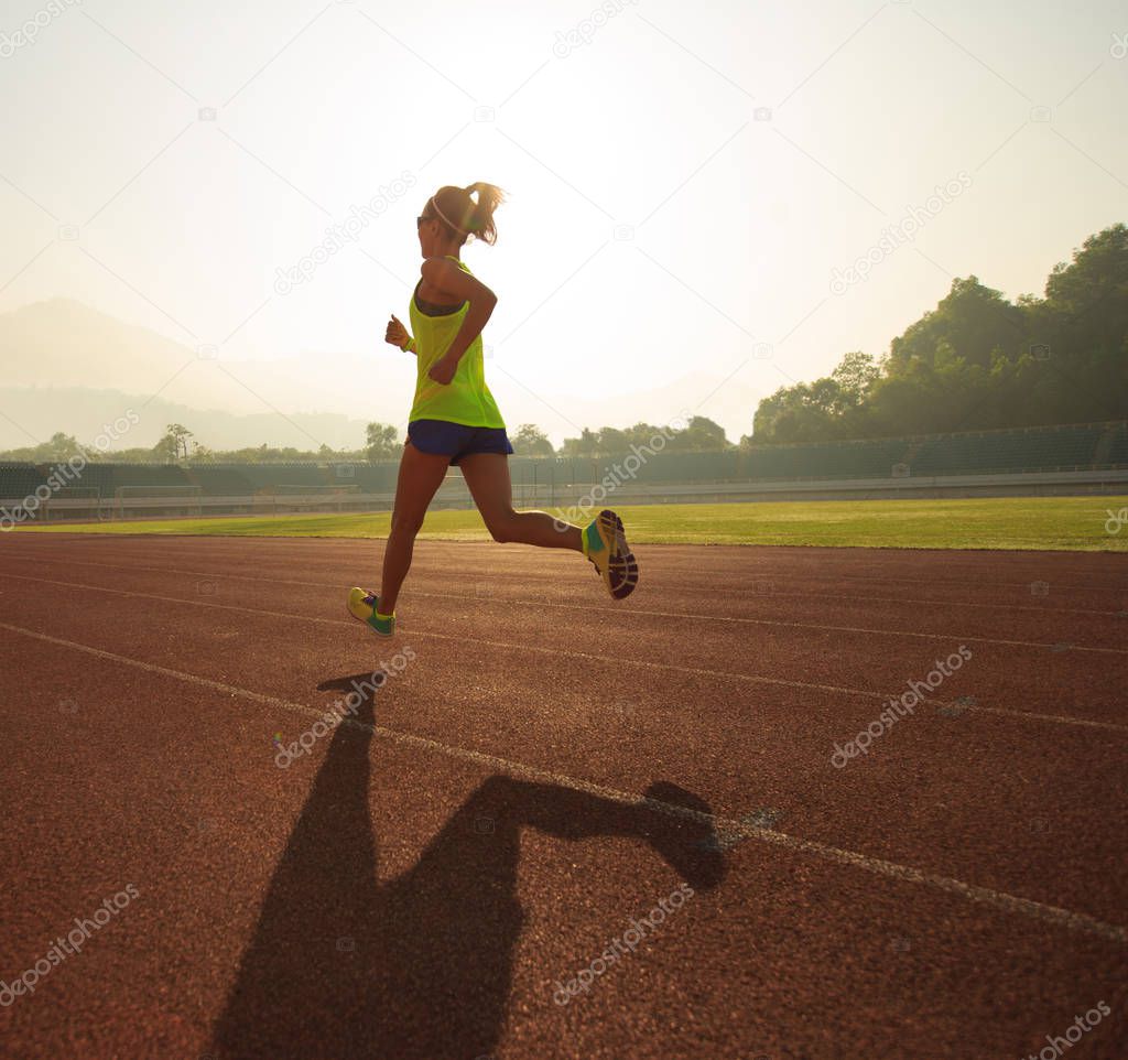 Young woman running on stadium  