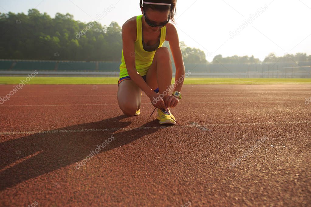 female runner tying shoelace 
