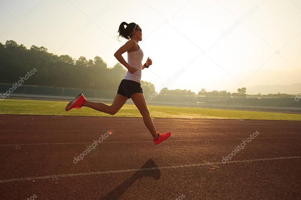 Young woman running on stadium  