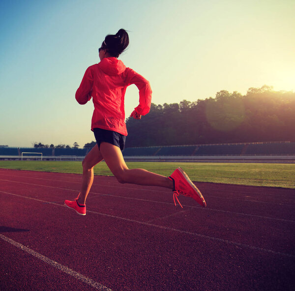Young woman running on stadium  