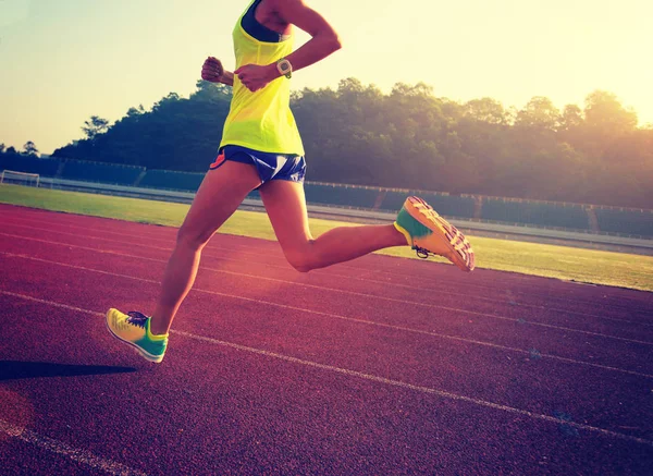 Mujer joven corriendo en el estadio — Foto de Stock