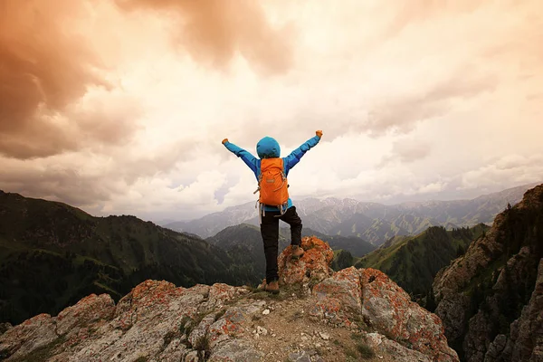 Kvinna med upphöjda armar på berg — Stockfoto