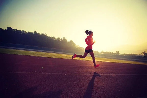 Mujer joven corriendo en el estadio — Foto de Stock