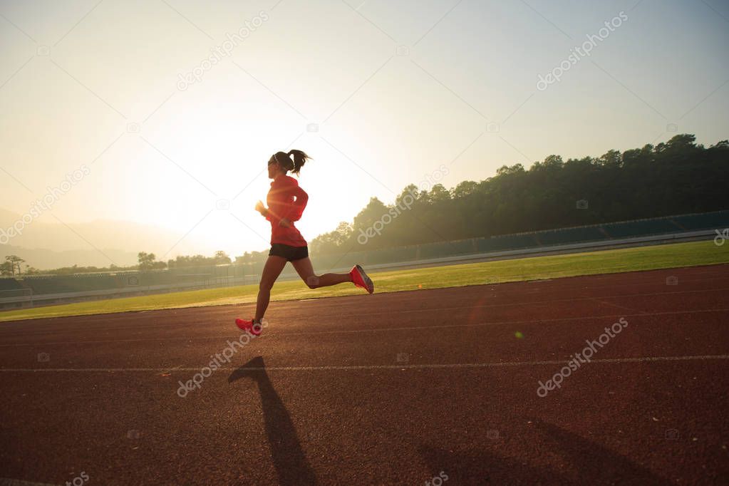 Young woman running on stadium  