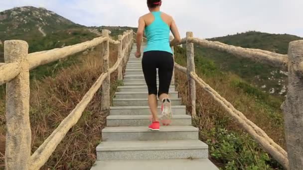 Young woman running on mountain stairs — Stock Video