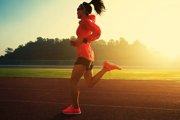 Mujer joven corriendo en el estadio — Foto de Stock