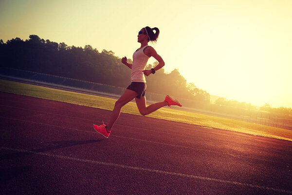 Young woman running on stadium  