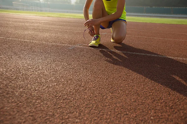 Vrouwelijke atleet gelijkmakende schoenveter — Stockfoto