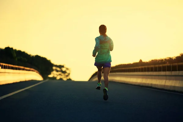 Young woman running on road — Stock Photo, Image